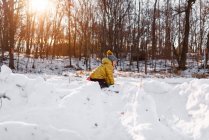 Menina sorridente construindo um forte de neve, Estados Unidos — Fotografia de Stock