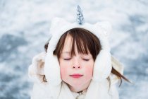 Portrait of a girl wearing unicorn ear muffs, United States — Stock Photo