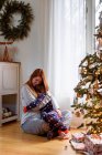 Mother and son hugging by christmas tree at home — Stock Photo