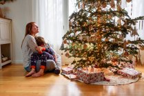 Mutter und Sohn umarmen sich zu Hause am Weihnachtsbaum — Stockfoto
