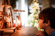 Хлопчик дивиться на різдвяні прикраси та свічки — стокове фото