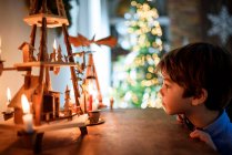 Хлопчик стоїть перед буфетом і дивиться на різдвяні прикраси. — стокове фото