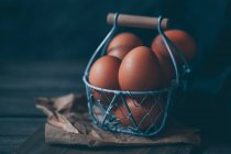 Яйца в металлической корзине на столе — стоковое фото