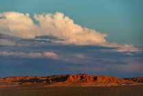 Puesta de sol y nubes de tormenta sobre acantilados llameantes, desierto de Gobi, Bulgan, Mongolia - foto de stock