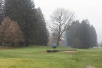 Чоловік, що переходив міст на полі для гольфу взимку (Німеччина). — стокове фото