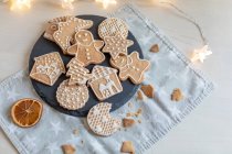 Christmas gingerbread cookies on a table with fairy lights — Stock Photo