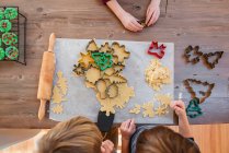 Vista aérea de tres niños haciendo galletas de Navidad - foto de stock