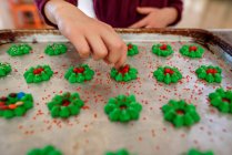 Mädchen steht in der Küche und dekoriert Kekse — Stockfoto