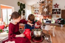 Two children in the kitchen making a cake — Stock Photo