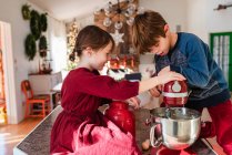 Двое детей на кухне делают торт — стоковое фото