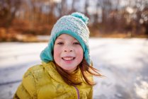Porträt eines lächelnden Mädchens, das an einem gefrorenen Teich steht, USA — Stockfoto