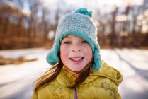 Portrait d'une fille souriante debout près d'un étang gelé, États-Unis — Photo de stock