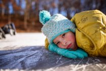 Retrato de uma menina deitada em um lago congelado, Estados Unidos — Fotografia de Stock