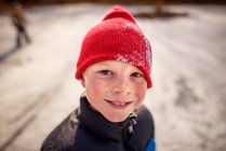 Retrato de um menino sorridente em pé junto a uma lagoa congelada, Estados Unidos — Fotografia de Stock