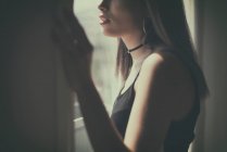 Adolescente olhando através de uma janela — Fotografia de Stock