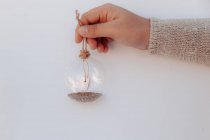 Girl's hand holding a glass bauble with a make a wish message — Stock Photo