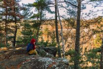 Мальчик, сидящий на улице в лесу, Соединенные Штаты — стоковое фото
