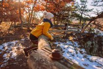 Chica apoyada en una valla de madera a finales de otoño, Estados Unidos - foto de stock