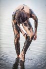 Girl standing in Atanasovsko Lake covering herself in mud, Burgas, Bulgaria — Stock Photo