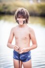 Мальчик, стоящий на озере Атанасовско, обливает грязью лицо, Бургас, Болгария — стоковое фото