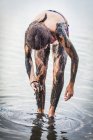 Chica de pie en el lago Atanasovsko cubriéndose de barro, Burgas, Bulgaria - foto de stock