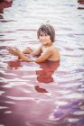 Мальчик, сидящий в озере Атанасовско, Бургас, Болгария — стоковое фото