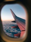 Airplane wing through an airplane window — Stock Photo