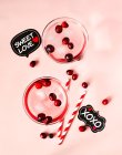 Red cranberry cocktail with vodka on pink background, top view. — Stock Photo