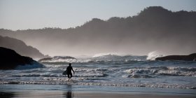 Un homme marche sur la plage le matin — Photo de stock