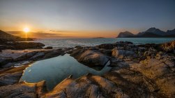 Malerischer Blick auf felsige Küste und welliges Meer bei Sonnenuntergang — Stockfoto
