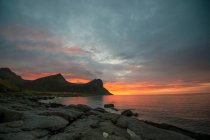 Vista pitoresca da costa rochosa e mar ondulado ao pôr do sol — Fotografia de Stock
