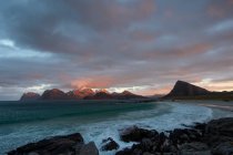 Pintoresca vista de la costa rocosa y el mar ondulado al atardecer - foto de stock