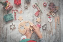 Дитина робить різдвяне печиво на столі, вид зверху — стокове фото