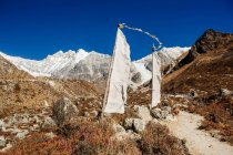 Bandiere di preghiera nel paesaggio montuoso sotto il cielo blu — Foto stock