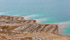 Pintoresca vista de la costa rocosa y el mar ondulado en el día soleado, Jordania - foto de stock