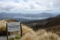 Warning sign at beautiful mountainous landscape with lake — Stock Photo