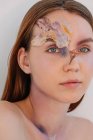 Conceptual beauty portrait of a woman with dried flowers on her face — Stock Photo