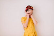 Retrato de uma menina cansada esfregando o rosto no fundo branco — Fotografia de Stock