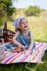 Smiling girl sitting on a picnic blanket in the park, Bulgaria — Stock Photo