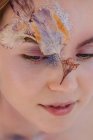 Portrait de beauté conceptuel d'une femme avec des fleurs séchées sur son visage — Photo de stock