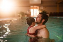 Батько тримає свою дочку в басейні — стокове фото