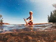Niño navegando en un lago en una balsa de madera, Lago Superior, Estados Unidos - foto de stock