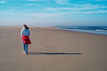 Mujer caminando por la playa en otoño, Juist, Frisia Oriental, Baja Sajonia, Alemania - foto de stock