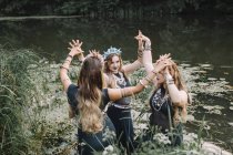 Tres mujeres boho bailando en un lago, Rusia - foto de stock