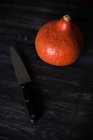 Orange pumpkin and knife on wooden table, close view — Stock Photo