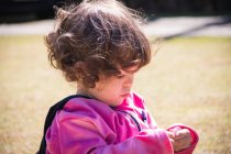 Porträt eines Mädchens im Park, das mit ihren Socken spielt — Stockfoto