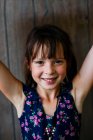 Portrait of a smiling girl in a summer dress with her arms raised — Stock Photo