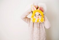Girl wearing bunny ears holding a bunny handbag in front of her face — Stock Photo
