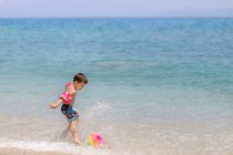 Мальчик, пинающий мяч на пляже, Греция — стоковое фото