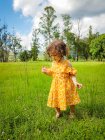 Девушка, стоящая в поле, играя с длинной травой, Бразилия — стоковое фото